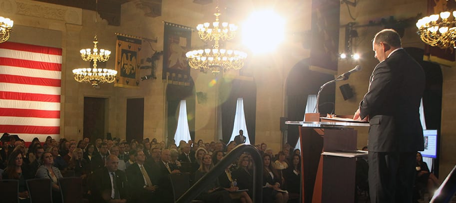 A man standing at a podium in front of a large crowd